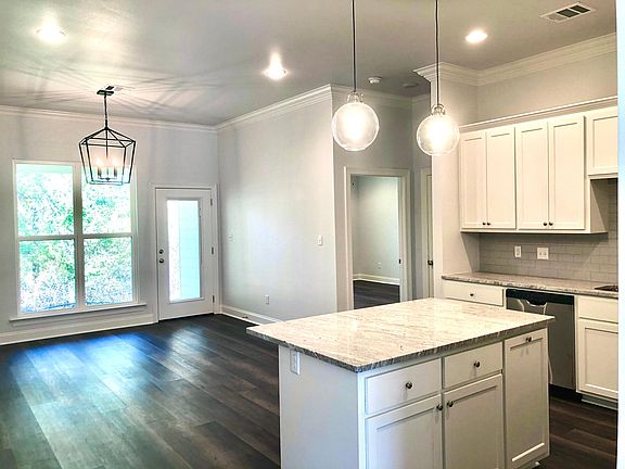 Spacious Dining Area with large windows overlooking backyard. Recessed light bulbs throughout. Overhanging countertop allows for entertaining in the kitchen.