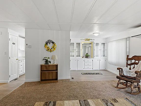 Living room with view of dine. New vinyl flooring in dine, Kitchen and entry. Fresh painted. Decorated with sunflowers. You may feel right at home in this very cute and clean home.
