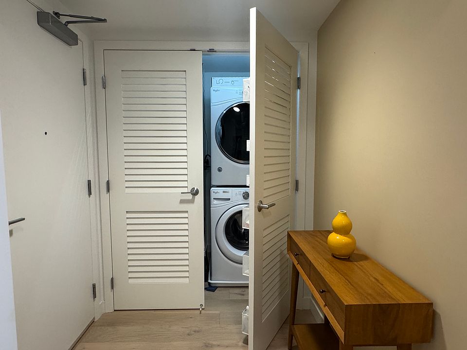 The entry area and in-unit washer and dryer. Coat and shoe storage are to the left of the washer and dryer.