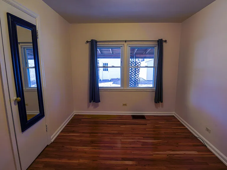 Bedroom One (NE) 8'.9.5" by 12'. View into the backyard.
