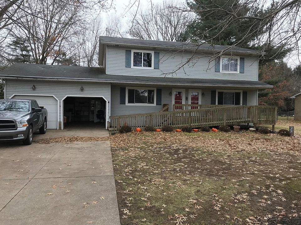 View from front, open garage is the one for the available unit. There are extra paved parking spaces to the left of the driveway