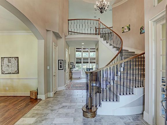 Elegant flowing staircase in entry with beautiful chandelier.