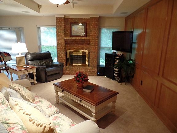 Open living room with wood burning fireplace.