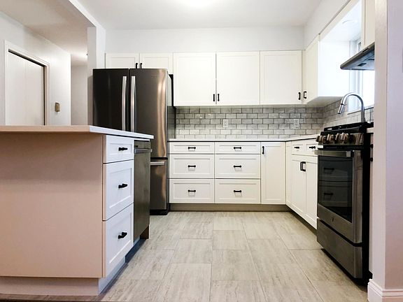 Kitchen view from the dining room. All new stainless steel appliances including a dishwasher in the island. Gas range, custom cabinets with soft close. Quartz countertops.