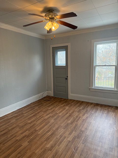 Bright living room with ceiling fan, and door to a spacious balcony