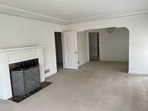 Living room looking into the dining room. The door on the left is to the hallway and bedrooms. The fireplace is functional and very cozy!