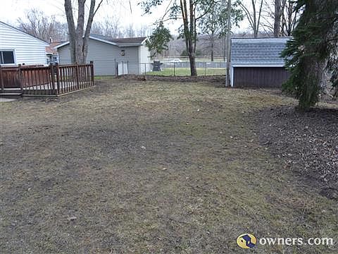 Fenced back yard with deck and large storage shed.