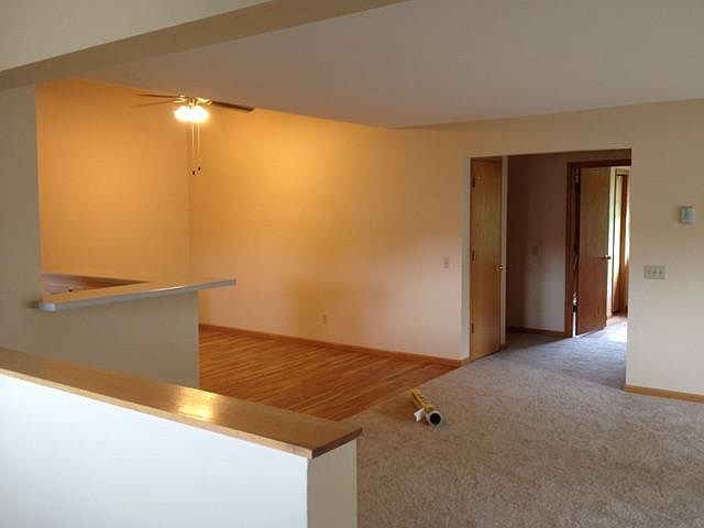 At the top of the stairway looking across the living room, into the dining room and hallway.