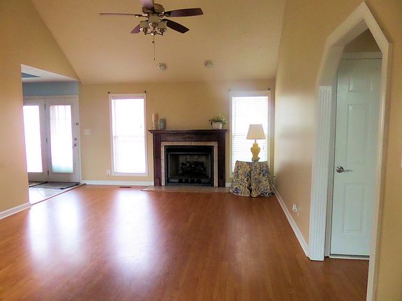 Spacious living room with a vaulted ceiling and a fireplace.