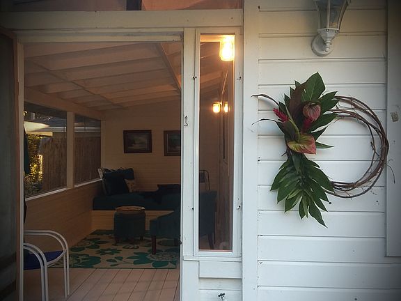 Walk into outdoor screened in lanai with puune'i or built in day bed. View looks at to the green Hawaiian flora all around you.