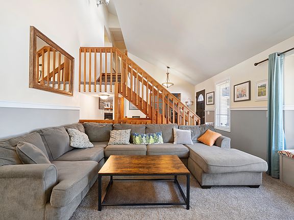 Front living room facing large window. Vaulted ceilings. Opens to the dining room.