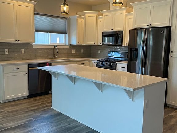 Kitchen, complete with quartz countertops & subway tile.