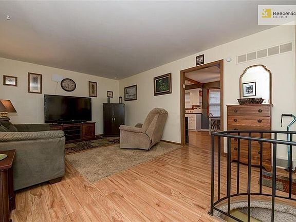 living room with spriral staircase to basement