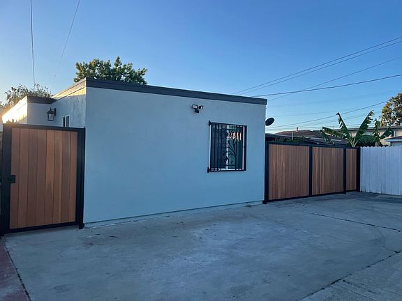 East wall with security light-motion sensor. Right gate is owner entrance to front house backyard.