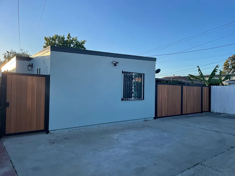 East wall with security light-motion sensor. Right gate is owner entrance to front house backyard.