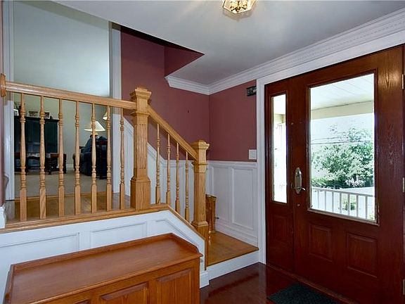 Hardwood floors and wainscoting welcomes guests into the foyer that leads to a well-maintained home.