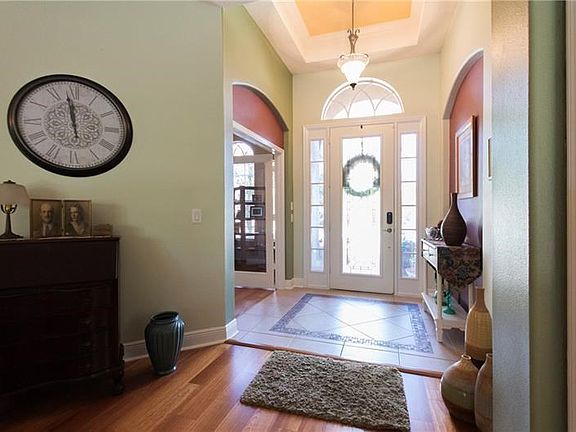 Dramatic entry with mosaic tiled floor and arched doorways.