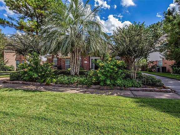 Low maintenance landscaping with a mix of green hedges, tropical palms & hibiscus, and soft green grass make this a yard you'll enjoy season after season.