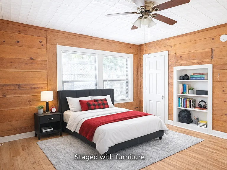 Middle bedroom with fun wood walls and built-in bookshelves