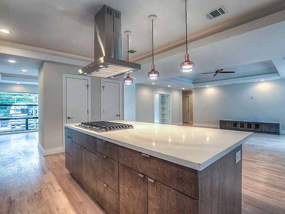 Kitchen island looking back into the great room _ large quartz prep surface, stainless island hood, and sightlines through the entire main living area