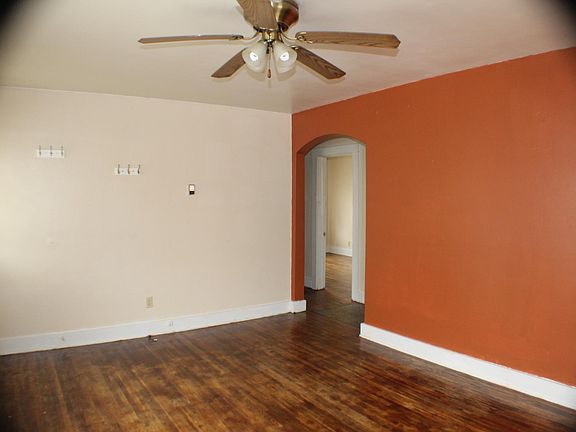 Living room with arched doorway and accent wall. 