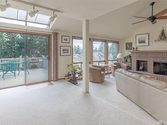 Turning around to the living room w/wood fireplace. Sliding door leads to deck.