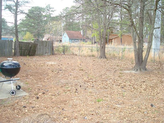 back yard fenced in with patio and shade trees