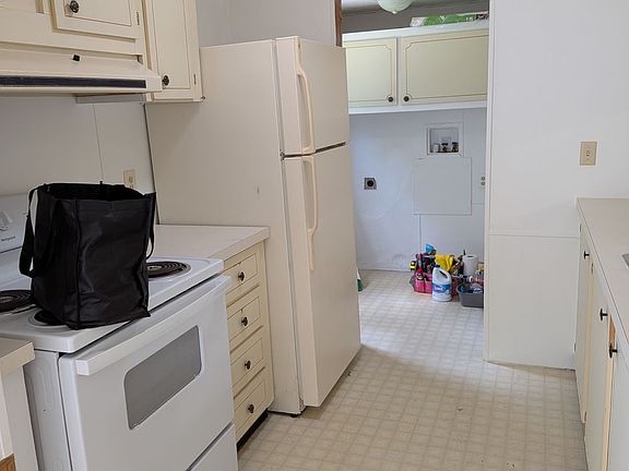 Kitchen view from dining room, leads to laundry room, pantry cabinets and back door