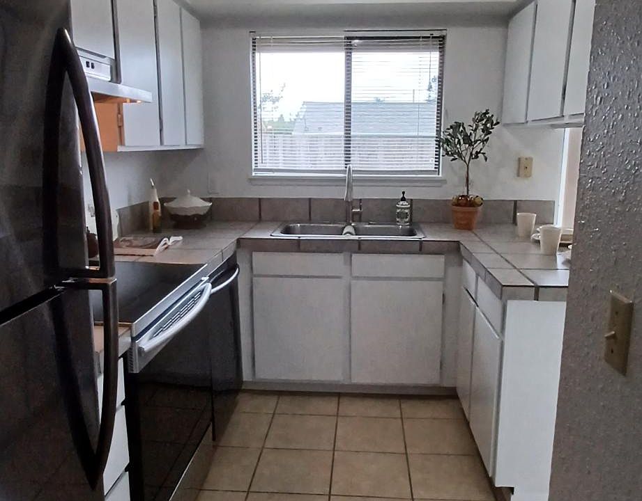 Nicely appointed galley kitchen with window to backyard over kitchen sink