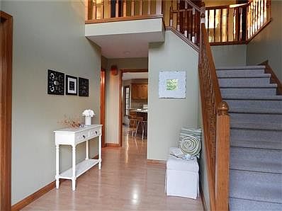 Large entry has huge window which lights the staircase and entry to den on left and living room on the right.