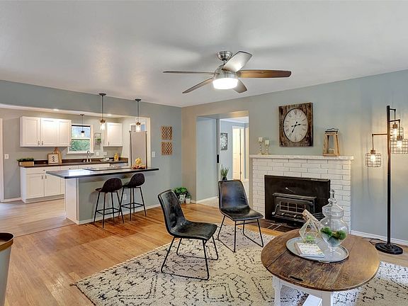 Open floor plan with original hardwood floors in living room, wood burning stove, newly remodeled kitchen, new paint.>