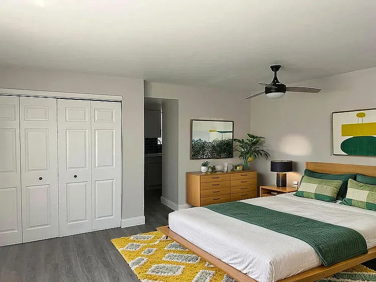 Elegant and modern bedroom with stylish decor, featuring a cozy bed, sleek wooden furniture, and vibrant accents, perfect for relaxation.