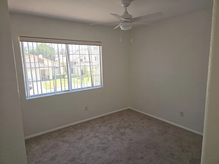 A well-lit bedroom #2 with ceiling fan awaits your personal touch.
