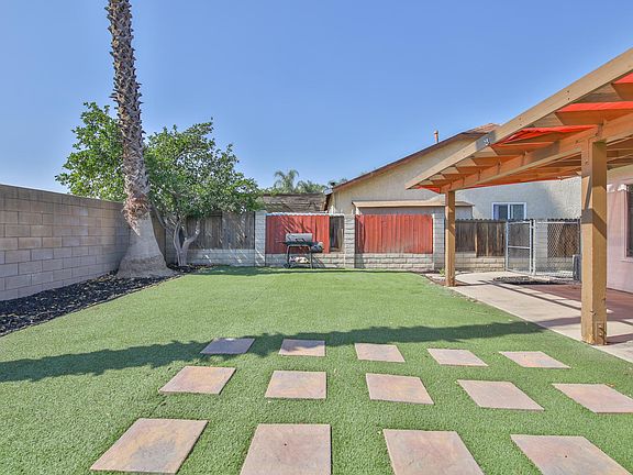 Large back yard with artificial lawn and lemon tree