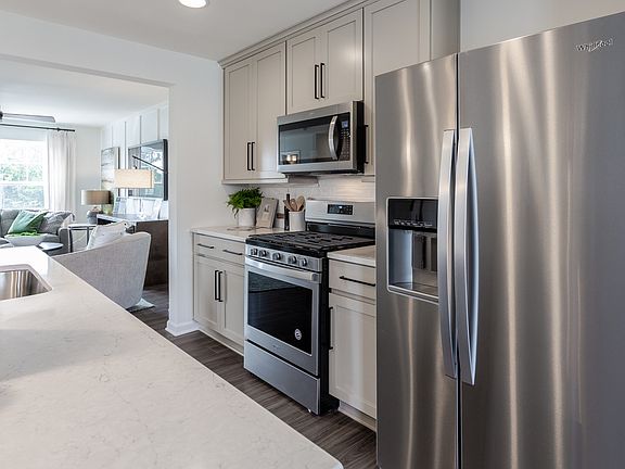 Island kitchen with stainless steel appliances in a DRB Homes York II model at the Archer s Rock com