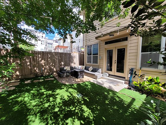 Yard includes: Brick deck, perfect for patio furniture; large Crape Myrtle providing ample shade; Dog run along side of house, with artificial grass throughout; String lights over patio with dimmable remote; and a spot for an outdoor grill