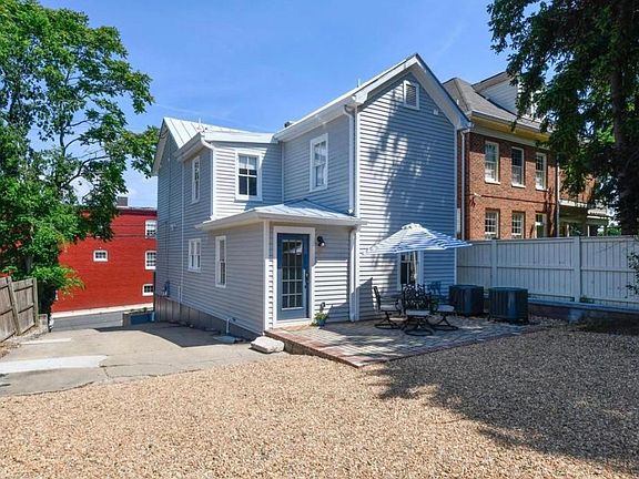back of the house with patio space and gravel extra parking