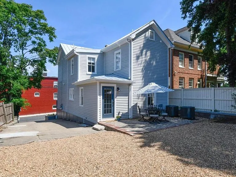 back of the house with patio space and gravel extra parking
