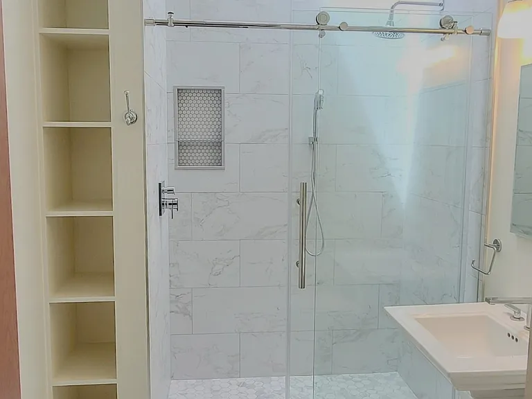 Primary bedroom's ensuite full bathroom with skylight, decorated with roman-greco marble tiling and the finest finishes.