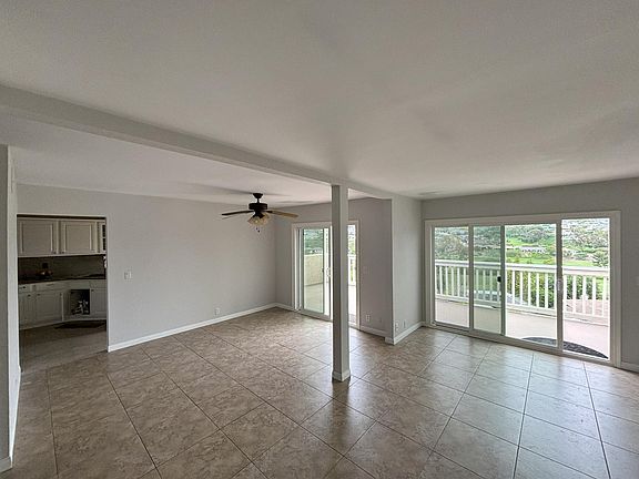 Living room area on the right, dining center left and kitchen far left. Golf course visible in background.