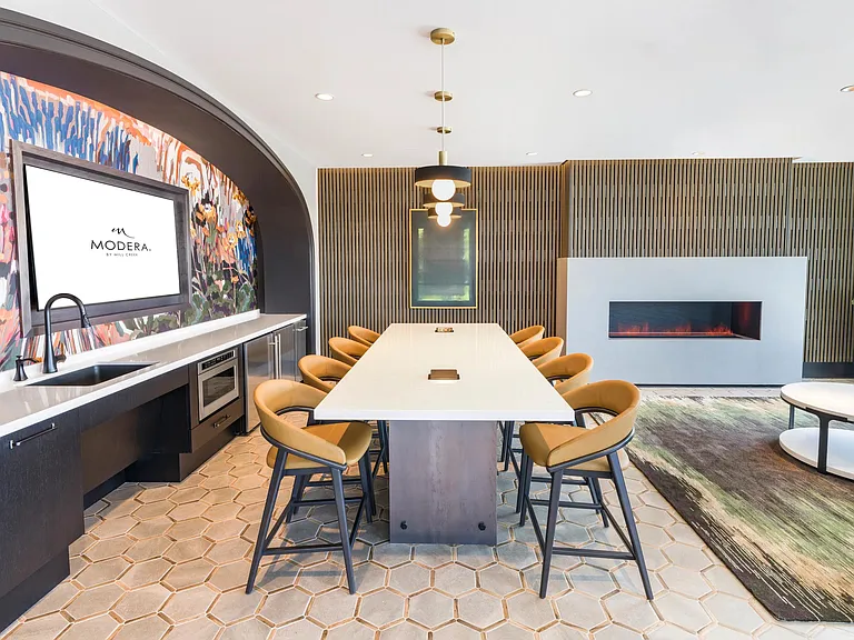 Whether you're hosting, collaborating, or catching the game, this vibrant clubroom with a kitchen, fireplace, and plenty of seating sets the perfect scene.