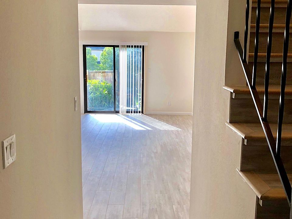 Entry into house. Peaked ceiling living room ahead. Kitchen entrance on left.