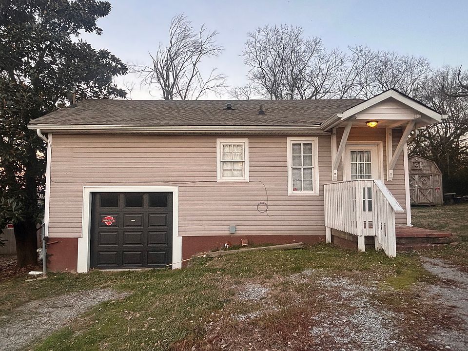 Front of home, including a new insulated garage door and handrail.