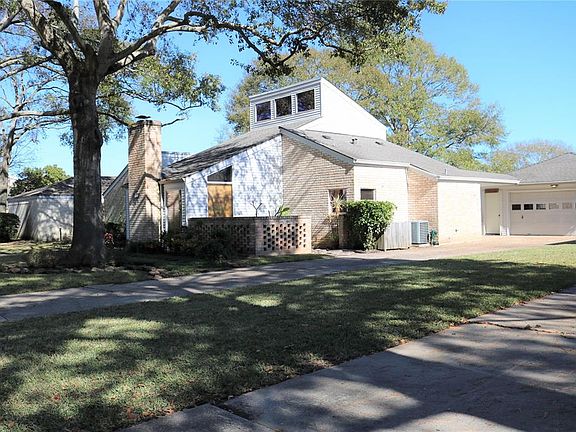 Side view of front showing long driveway and detached garage. Nice windows into the kitchen.