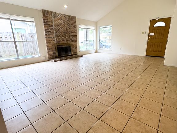 Huge living room and dining room combo with a fireplace, tall windows, vaulted ceilings