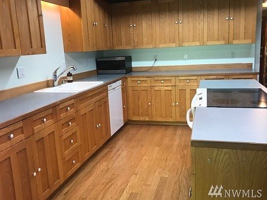 Oak floors, custom cabinets and plenty of counter space in the kitchen offer substantial storage and great work flow. 