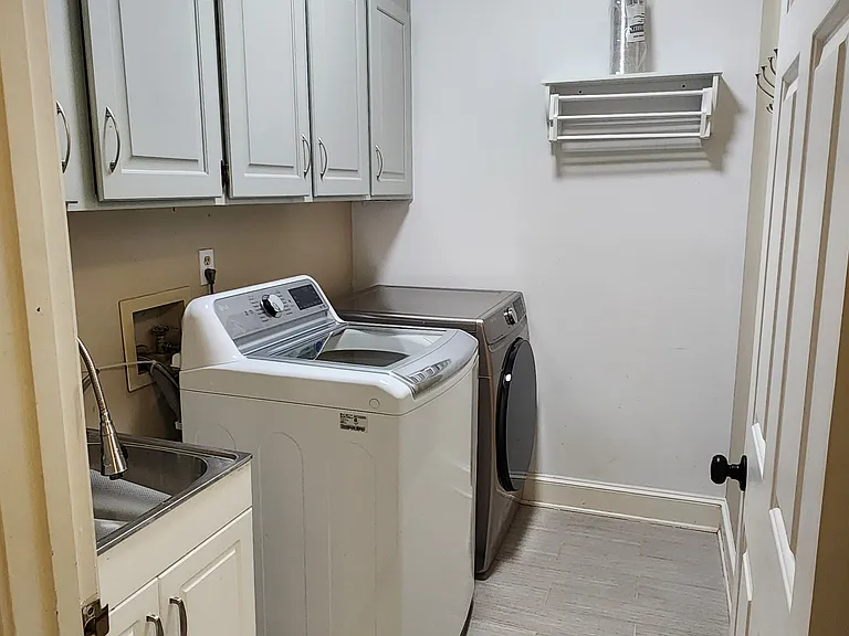 Laundry with washer and dryer and sink.