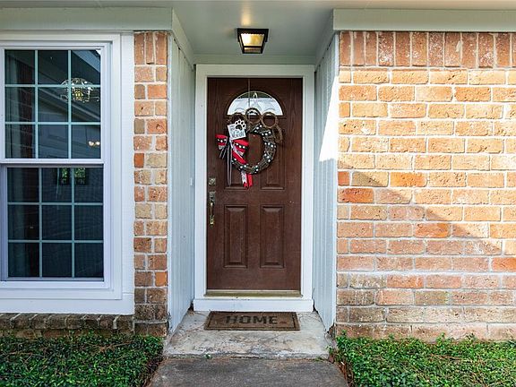 A covered entry leads to the wood and leaded-glass front door.