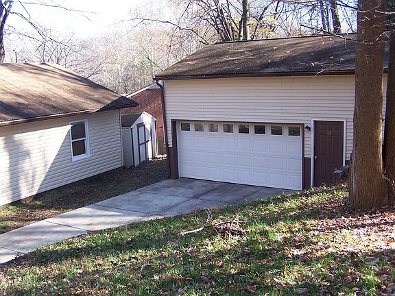 back of home with garage and other shed