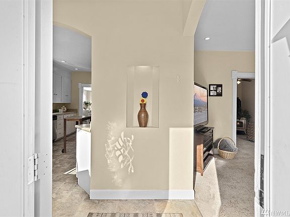 Beautiful entryway with recessed art alcove to show off your favorite artwork! Notice the flair that the archways to the kitchen and living room provide.